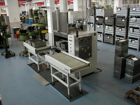 Frontlader FR 90 – Reinigungsanlage für industrielle Fertigung Frontlader FR 90 mit Rollenbahn in industrieller Produktionshalle