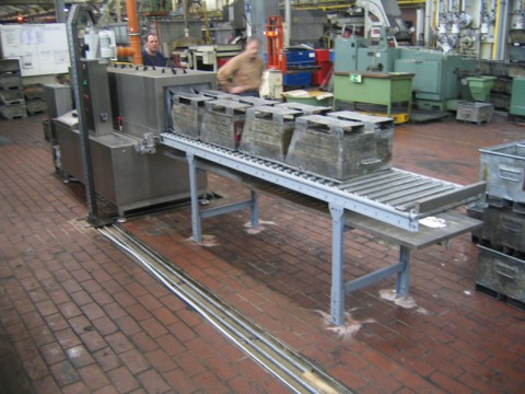 TW 106 – Durchlaufanlage mit Rollenbahn zur Behälterreinigung Durchlaufreinigungsanlage TW 106 mit Transportbehältern auf Rollenbahn im Umlauf
