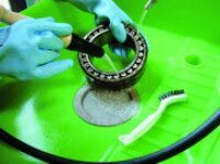 Brush cleaning - targeted manual reworking in PERKUTE system Brush cleaning of a metal part with a brush in a PERKUTE cleaning system