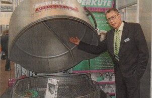 Martin Pricker in front of the PERKUTE SPF 120 at the Hannover Messe - industrial cleaning system for tools and machine components
